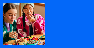 Two girls having snacks of fruit, cookies and minis